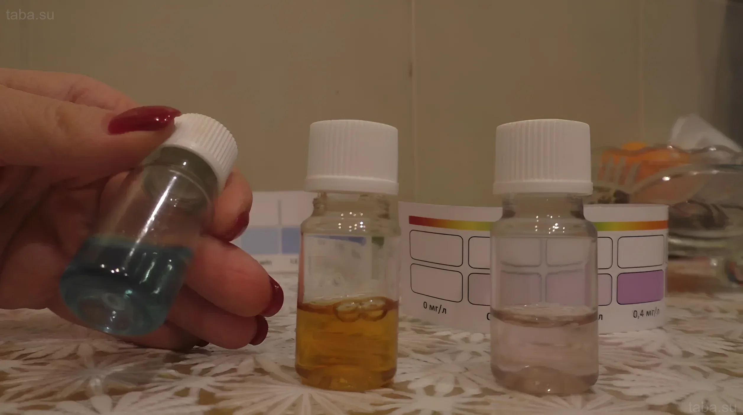 Photographie de tubes à essai contenant des liquides indicateurs pour déterminer le pH de l'eau d'aquarium. Différentes teintes indiquent différents niveaux d'acidité.