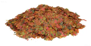 Фотография красочного рыбьего корма в виде хлопьев, демонстрирующая разнообразие ингредиентов и привлекательный внешний вид для аквариумных рыбок.